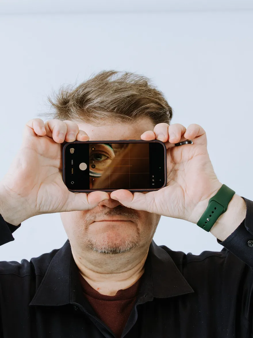 Jeff Fields framing a shot with his phone held up like a camera viewfinder