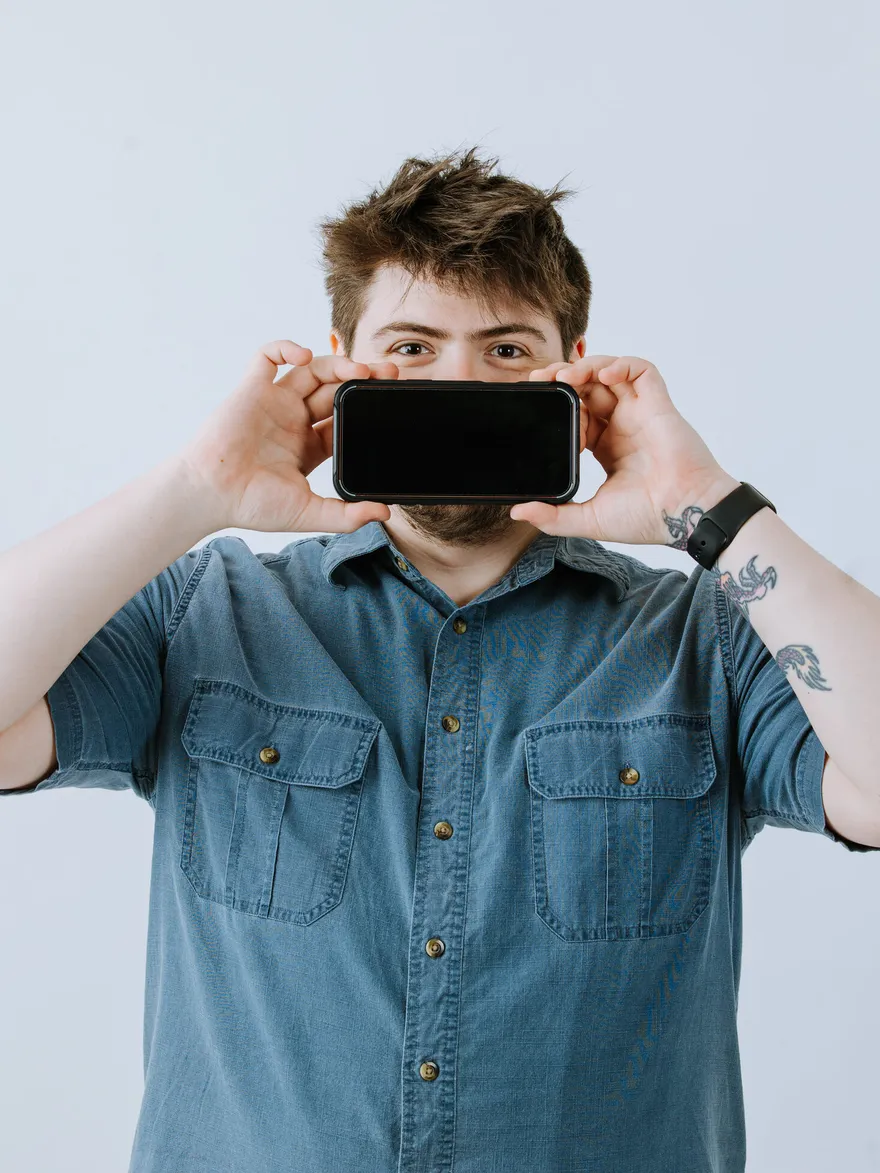 Tony Fiero framing a shot with his phone held up like a camera viewfinder